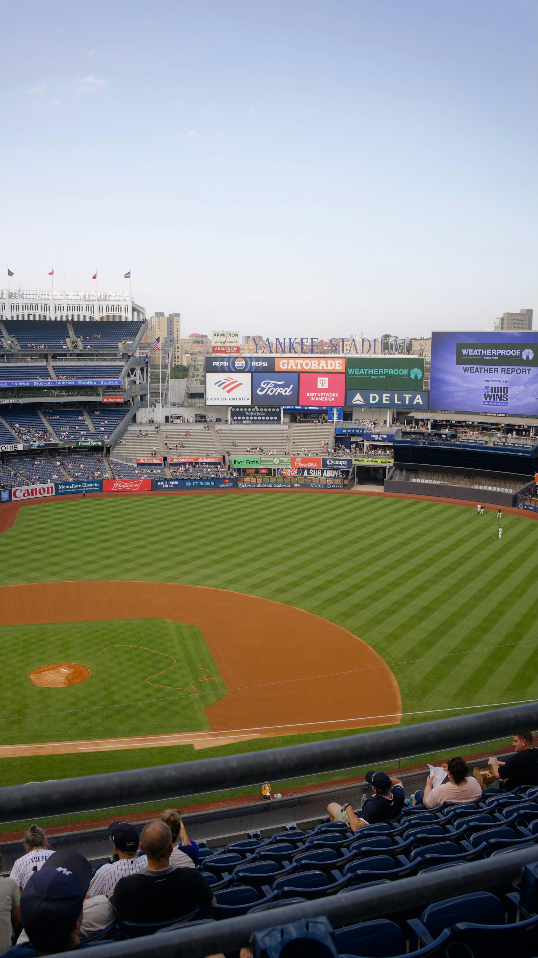 Baseball stadium view with fans in the stands and bright field lighting
